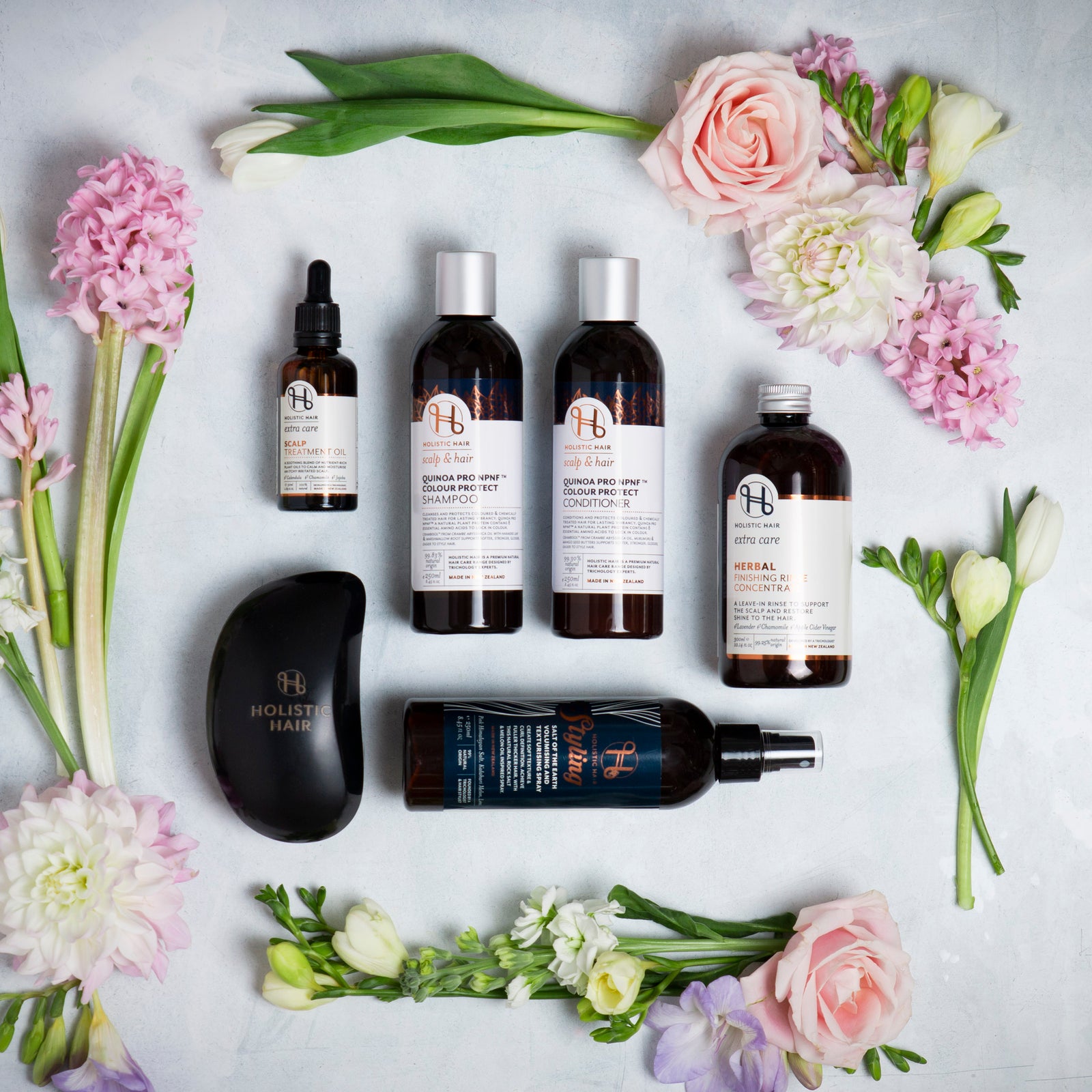 Image of a range of Holistic Hair products on a botanical background.